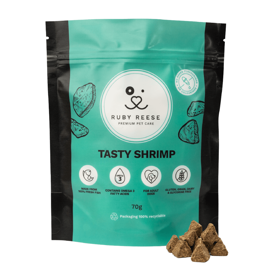 A turquoise pouch of RUBY REESE TASTY SHRIMP natural dog treats with a ziplock and some treats spilled in front of it