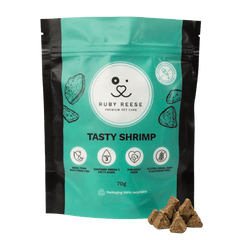 A turquoise pouch of RUBY REESE TASTY SHRIMP natural dog treats with a ziplock and some treats spilled in front of it